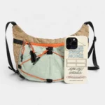 Sac Banane Randonnée Ultraléger Double Sangle Sac banane beige et vert en nylon ripstop posé de face à côté d'un smartphone qui donne son échelle