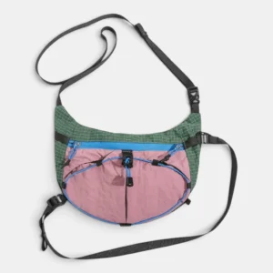 Sac banane de randonnée en nylon ripstop vert et rose posé à plat vu de face avec ses deux sangles déployées