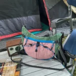 Sac Banane Randonnée Ultraléger Double Sangle Sac banane vert et rose en nylon ripstop posé sur une table de camping devant une tente