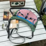 Sac Banane Randonnée Ultraléger Double Sangle Sac banane vert et rose posé à plat vu de dessus avec ses deux sangles entièrement déployées