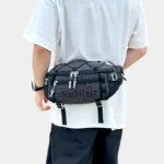 Grand Sac Banane Randonnée Dos Rembourré Sac banane en nylon ripstop noir à quadrillage blanc porté à la taille dans le dos par un homme