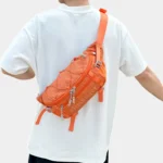 Grand Sac Banane Randonnée Dos Rembourré Sac banane en nylon ripstop orange porté en bandoulière dans le dos par un homme avec son cordon élastique croisé