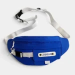 Grand Sac Banane Techwear Bleu Roi Sac banane techwear en nylon posé à plat de face avec large sangle blanche et boucle clip noire