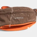 Sac Banane Coupe-Vent Années 90 Déperlant Gros plan sur le nylon ripstop déperlant du sac banane coupe-vent années 90 marron où perlent des gouttes d'eau