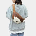 Sac Banane Enfant Multipoche Lettre Brodée Sac banane enfant marron à poche avant crème porté en bandoulière dans le dos par un enfant