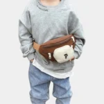 Sac Banane Enfant Multipoche Lettre Brodée Sac banane enfant marron à poche avant crème porté à la taille par un enfant de face