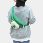 Sac Banane Enfant Multipoche Lettre Brodée Sac banane enfant vert à poche avant crème porté en bandoulière dans le dos par un enfant