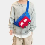 Sac Banane Enfant Voiture Sac banane enfant bleu à poche voiture rouge porté en bandoulière sur le ventre d'un enfant