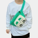 Sac banane enfant vert jade à poche blanche porté en bandoulière sur le ventre d'un enfant