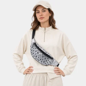 Sac banane facettes géométriques argenté métallique porté en bandoulière par une femme de face au style sporty-chic