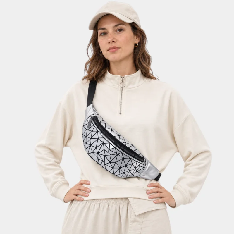 Sac banane facettes géométriques argenté métallique porté en bandoulière par une femme de face au style sporty-chic