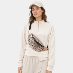 Sac banane à facettes géométriques doré métallique porté en bandoulière par une femme au style sportswear chic