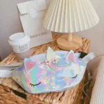 Sac banane licorne holographique blanc nacré aux reflets irisés posé sur un panier en osier