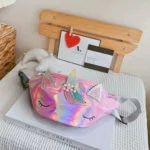 Sac banane licorne holographique rose posé sur un livre dans une chambre d'enfant décorée
