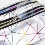 Sac Banane Géométrique Multicolore Brillant Festival Sac banane géométrique en cuir brillant argenté, gros plan sur la poche zippée ouverte avec une paire de lunettes posée dessus