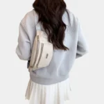 Sac Banane Imprimé Japonais Feuilles Argentées Sac banane demi-lune beige porté en bandoulière dans le dos par une femme vue de dos