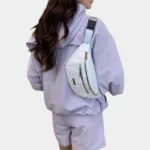 Sac Banane Imprimé Japonais Feuilles Argentées Sac banane demi-lune blanc porté en bandoulière dans le dos par une femme vue de dos