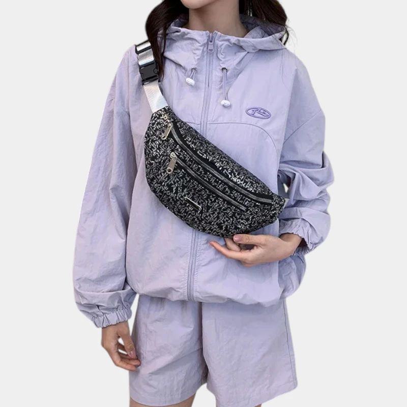 Sac banane demi-lune noir porté en bandoulière sur la poitrine par une femme de face