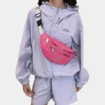 Sac Banane Imprimé Japonais Feuilles Argentées Sac banane demi-lune rose framboise porté en bandoulière sur la poitrine par une femme de face