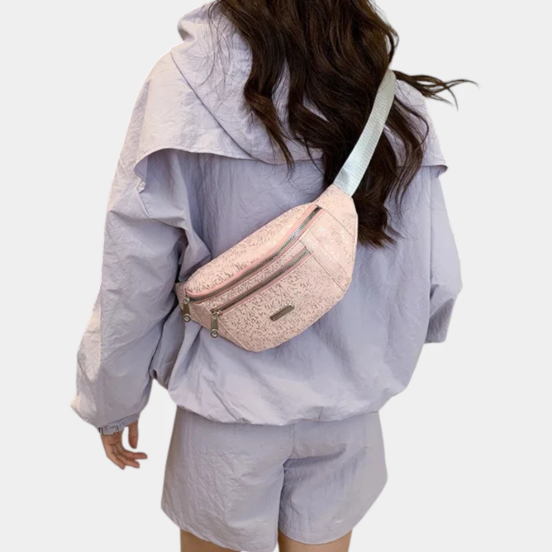 Sac banane demi-lune rose poudré porté en bandoulière dans le dos par une femme vue de dos