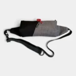 Sac Banane Rectangulaire Allongé Nylon Ripstop Déperlant Sac banane en nylon ripstop noir vu de trois quarts, sangle plate déployée avec son anneau de réglage.