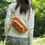 Sac Banane Bandoulière Randonnée Élastique Porte-Gourde femme portant le sac banane orange en bandouliere croisee