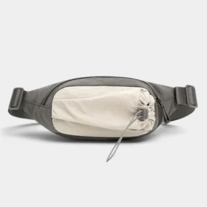 Sac banane en nylon gris de face avec poche avant beige serrée par un cordon élastique