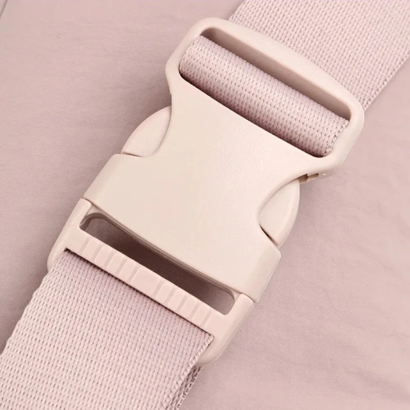 Sac banane en nylon rose pâle en gros plan sur la boucle clip en plastique de la ceinture tissée