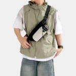 Sac Banane Randonnée Poche Gourde Nylon Déperlant Sac banane en nylon noir porté en bandoulière sur la poitrine par un homme avec une gourde dans la poche avant