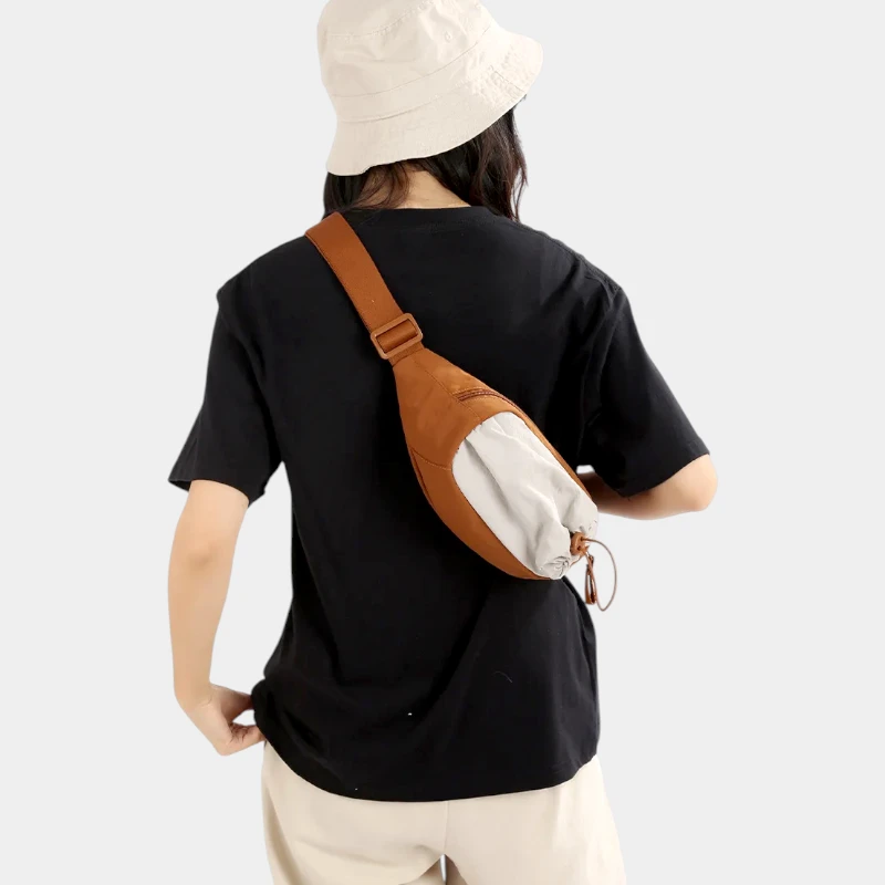 Sac banane en nylon orange porté en bandoulière dans le dos par une femme avec poche avant à cordon