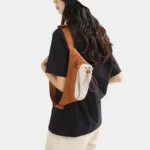Sac Banane Randonnée Poche Gourde Nylon Déperlant Sac banane en nylon orange porté en bandoulière dans le dos par une femme, de trois-quarts