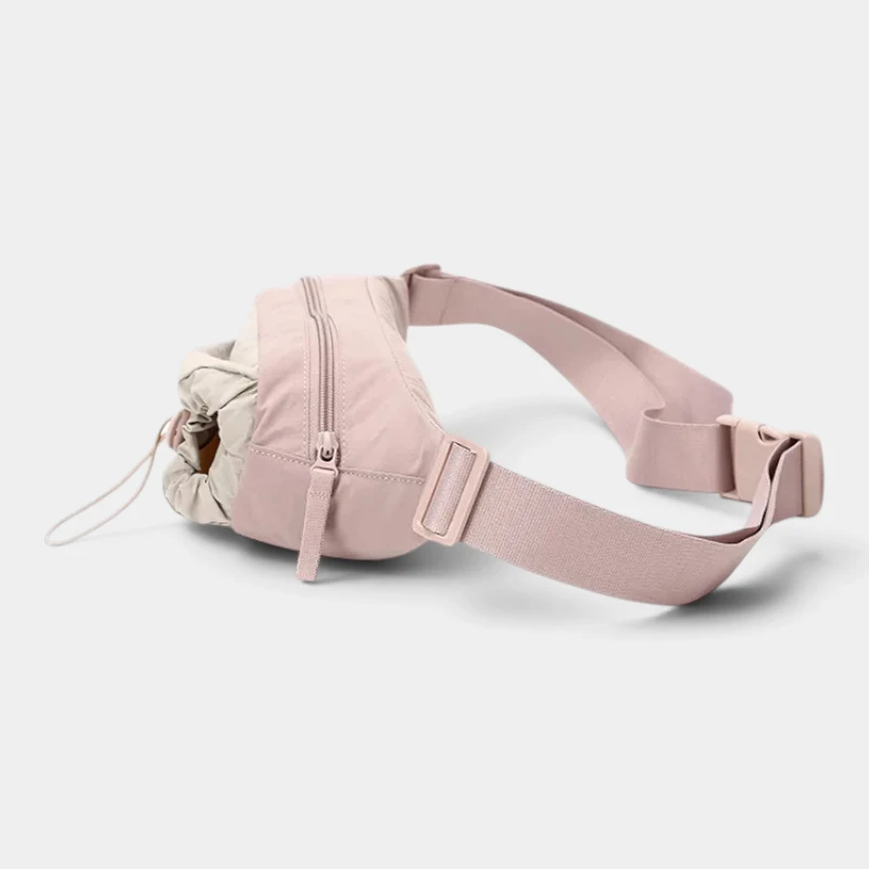 Sac banane en nylon rose pâle vu de côté avec fermeture éclair à tirette en sangle et boucle clip