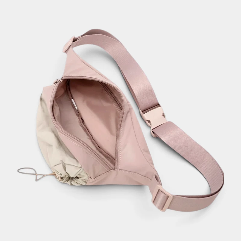 Sac banane en nylon rose pâle ouvert vu de dessus avec compartiment principal et poche intérieure zippée