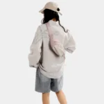 Sac Banane Randonnée Poche Gourde Nylon Déperlant Sac banane en nylon rose pâle porté en bandoulière dans le dos par une femme avec poche avant à cordon