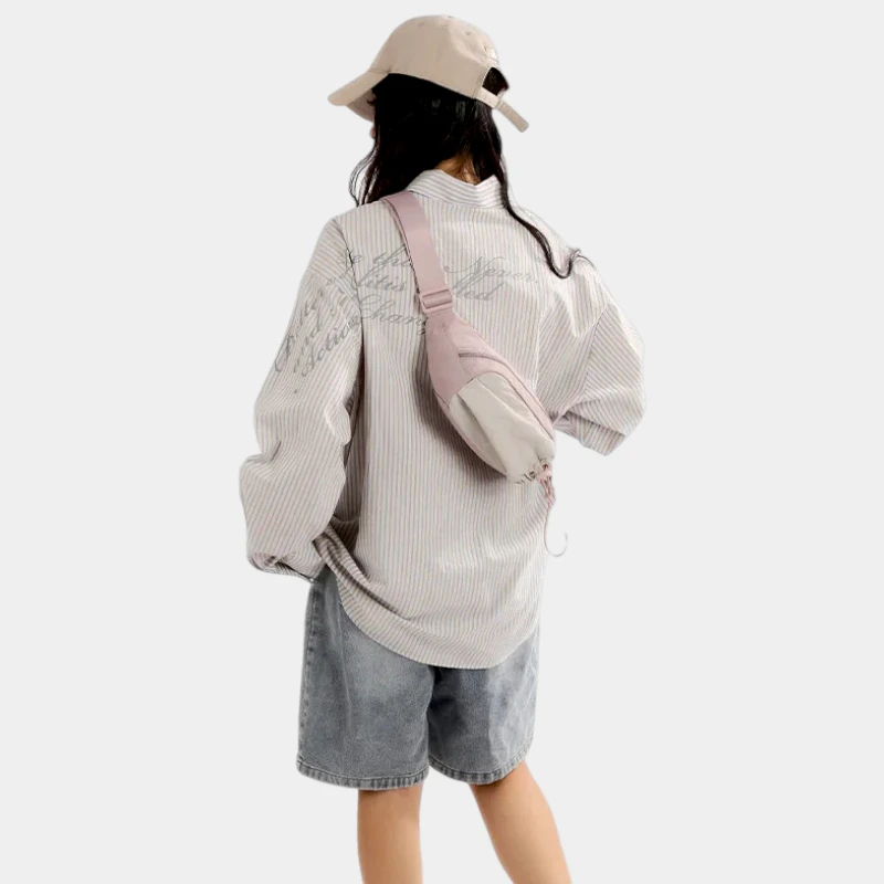Sac banane en nylon rose pâle porté en bandoulière dans le dos par une femme avec poche avant à cordon