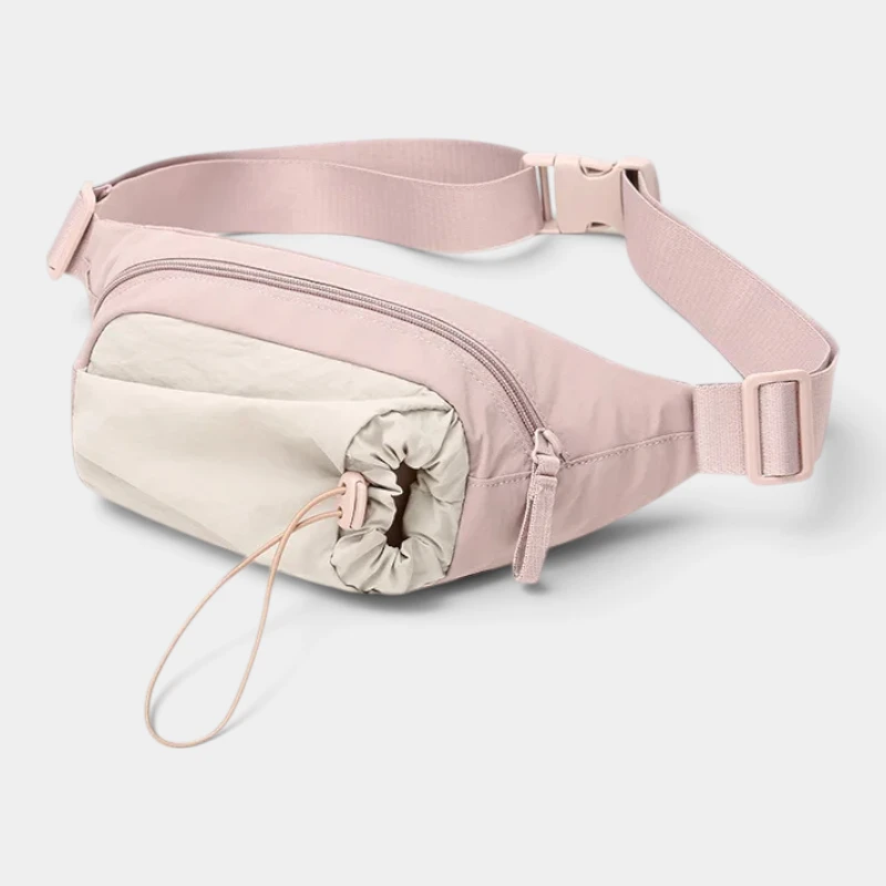 Sac banane en nylon rose pâle vu de trois-quarts avec poche avant serrée par un cordon élastique