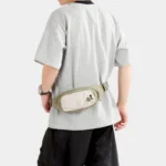 Sac Banane Randonnée Poche Gourde Nylon Déperlant Sac banane en nylon vert kaki porté à la taille par un homme de dos avec poche avant à cordon