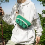Sac Banane Bandoulière Randonnée Élastique Porte-Gourde randonneur portant le sac banane vert en bandouliere