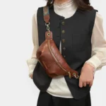 Sac banane simili cuir marron porté en bandoulière croisée par une femme au style chic ethnique