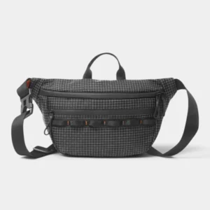 Sac banane noir en nylon ripstop à quadrillage blanc posé de face sur fond gris
