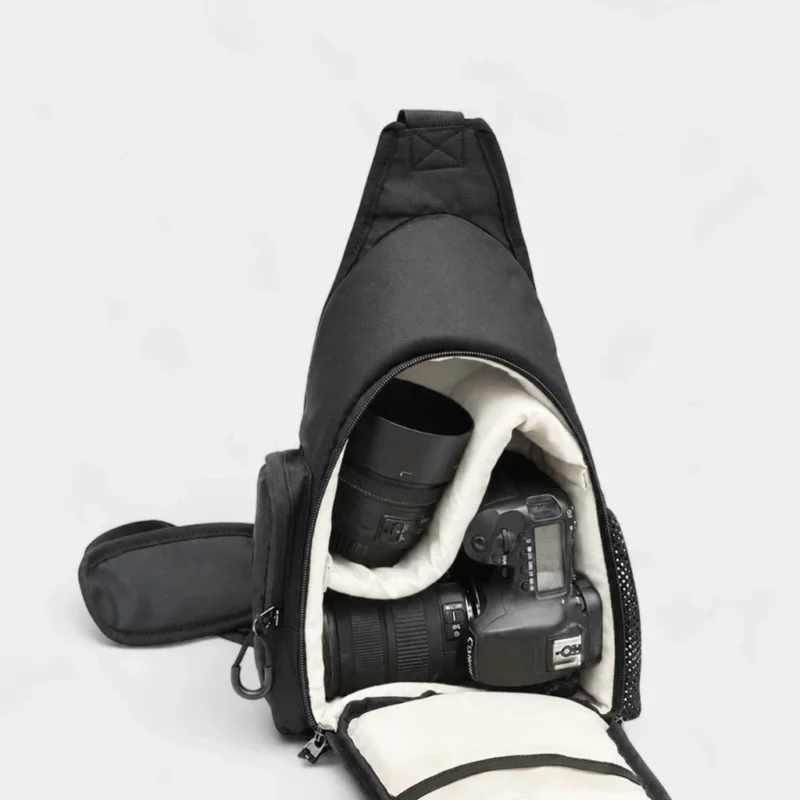 Sac banane photo ouvert avec un appareil photo et deux objectifs calés grâce au compartiment amovible