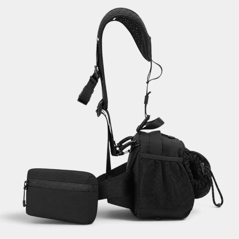 Sac banane en nylon noir vu de côté sur son harnais avec poche latérale en filet et pochette zippée sur la ceinture