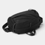 Sac banane en nylon ripstop noir posé et vu de dessus avec fourreau à cordon et poches latérales en filet