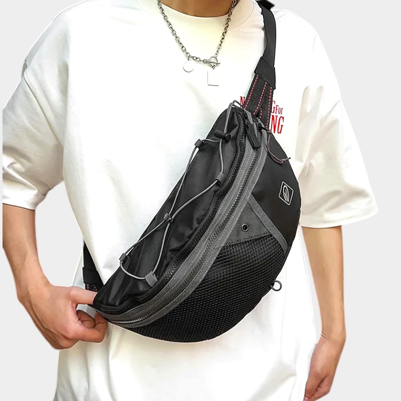 Sac banane noir porté en bandoulière sur le torse par un homme de face avec cordon élastique croisé