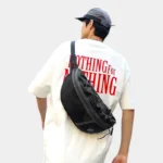 Grand Sac Banane Streetwear Nylon Poche Filet Sac banane noir porté en bandoulière dans le dos par un homme vu de dos au style streetwear