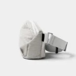 Sac banane gris clair à fin quadrillage blanc vu de côté avec sa ceinture réglable par boucle coulissante
