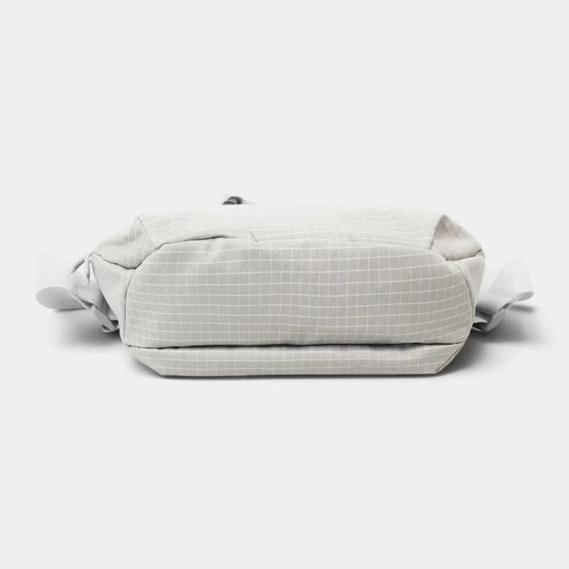 Sac banane gris clair à fin quadrillage blanc vu par le dessous avec sa base plate et ses attaches de ceinture