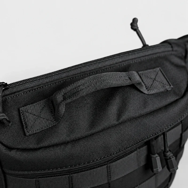 Sac banane tactique en nylon noir vu de dessus en gros plan avec poignée de transport en sangle cousue