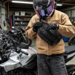 Grand Sac Banane Tactique Armée Velcro MOLLE Sac banane tactique en nylon noir porté en bandoulière sur la poitrine par un motard ganté qui l'ouvre