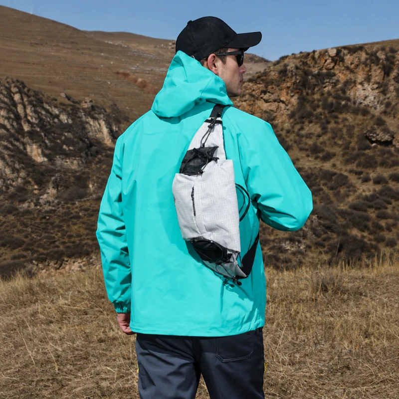 Sac banane blanc porté en bandoulière dans le dos par un homme lors d'une randonnée en montagne